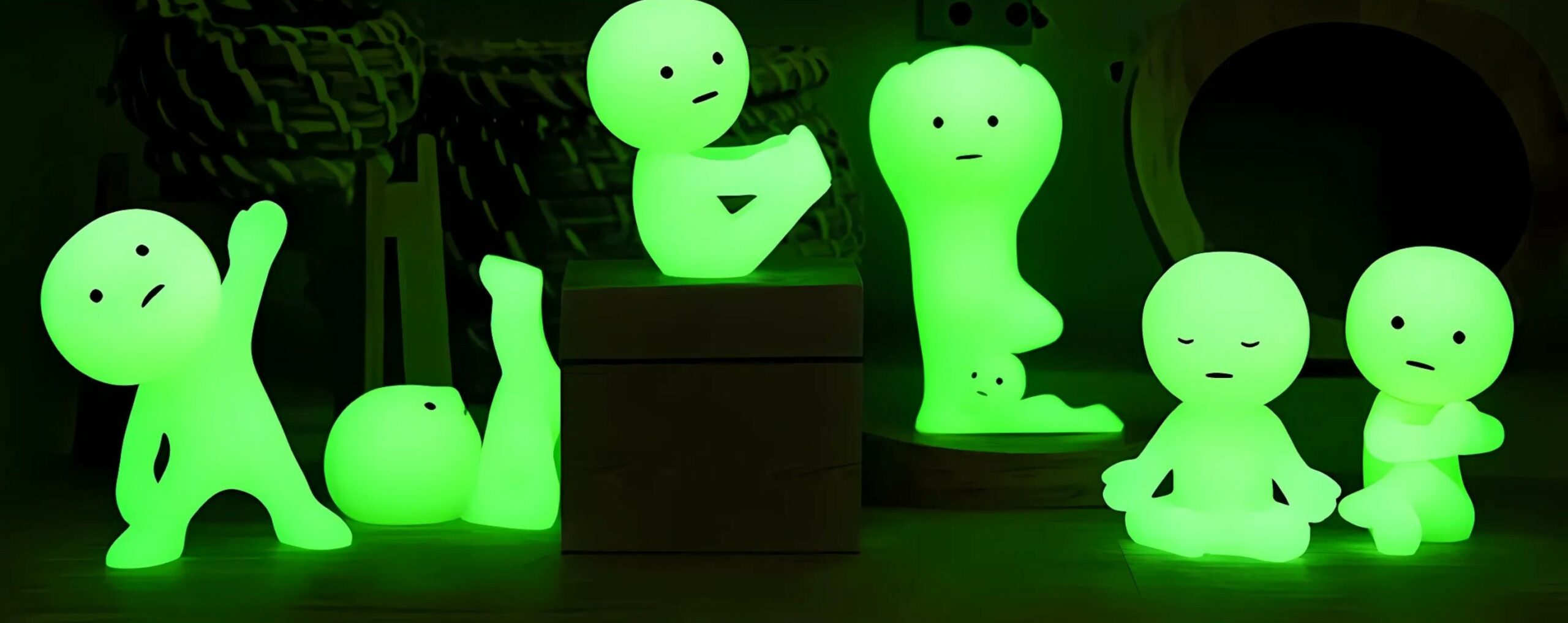 Glowing green night lights shaped like quirky human figures, ideal for children's bedroom decor.