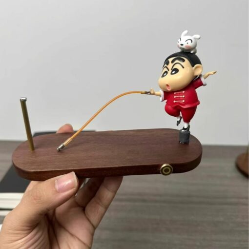 Cute figurine on a wooden base with a balancing toy design, featuring a playful character in a red outfit.